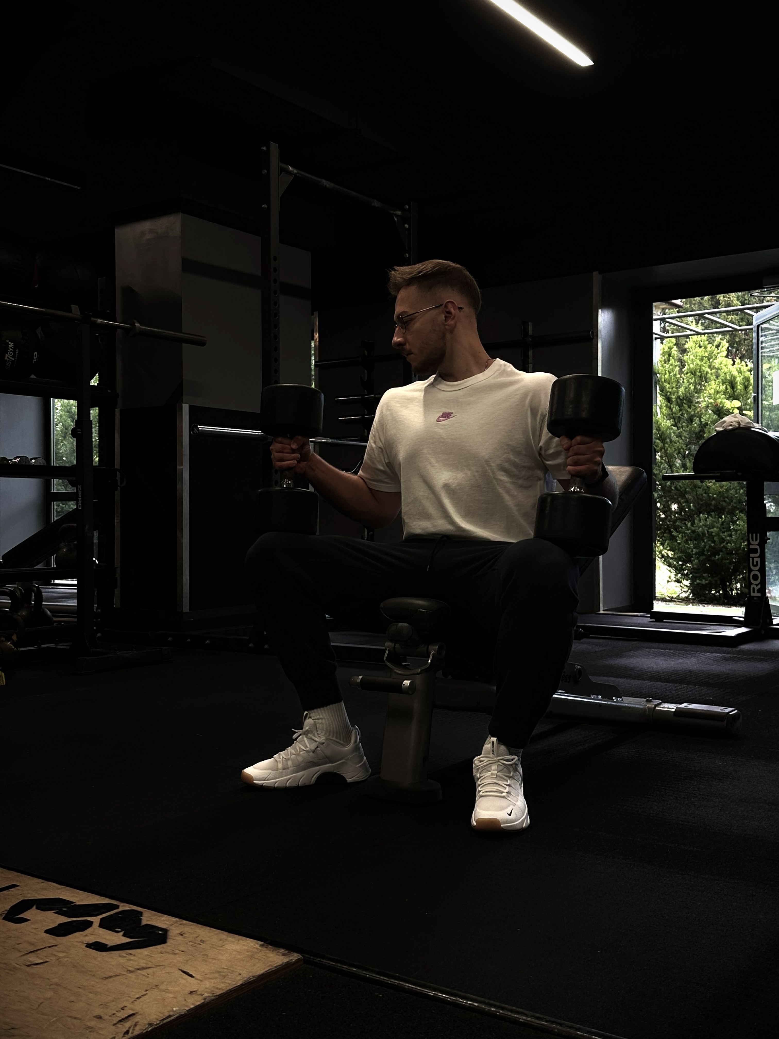 Jakub Pokora z hantlami na ławce treningowej