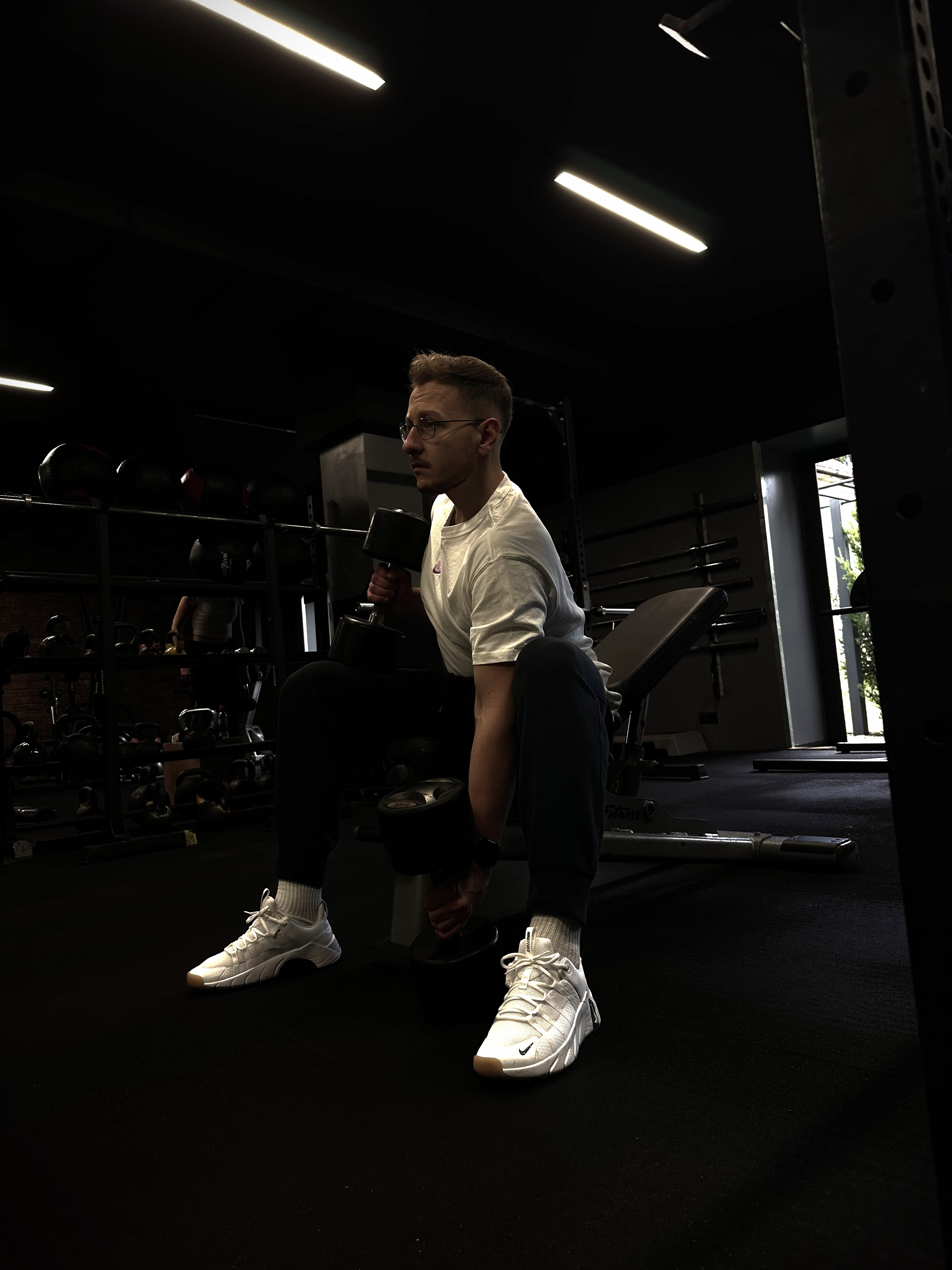 Jakub Pokora z hantlami w strefie wolnych ciężarów
